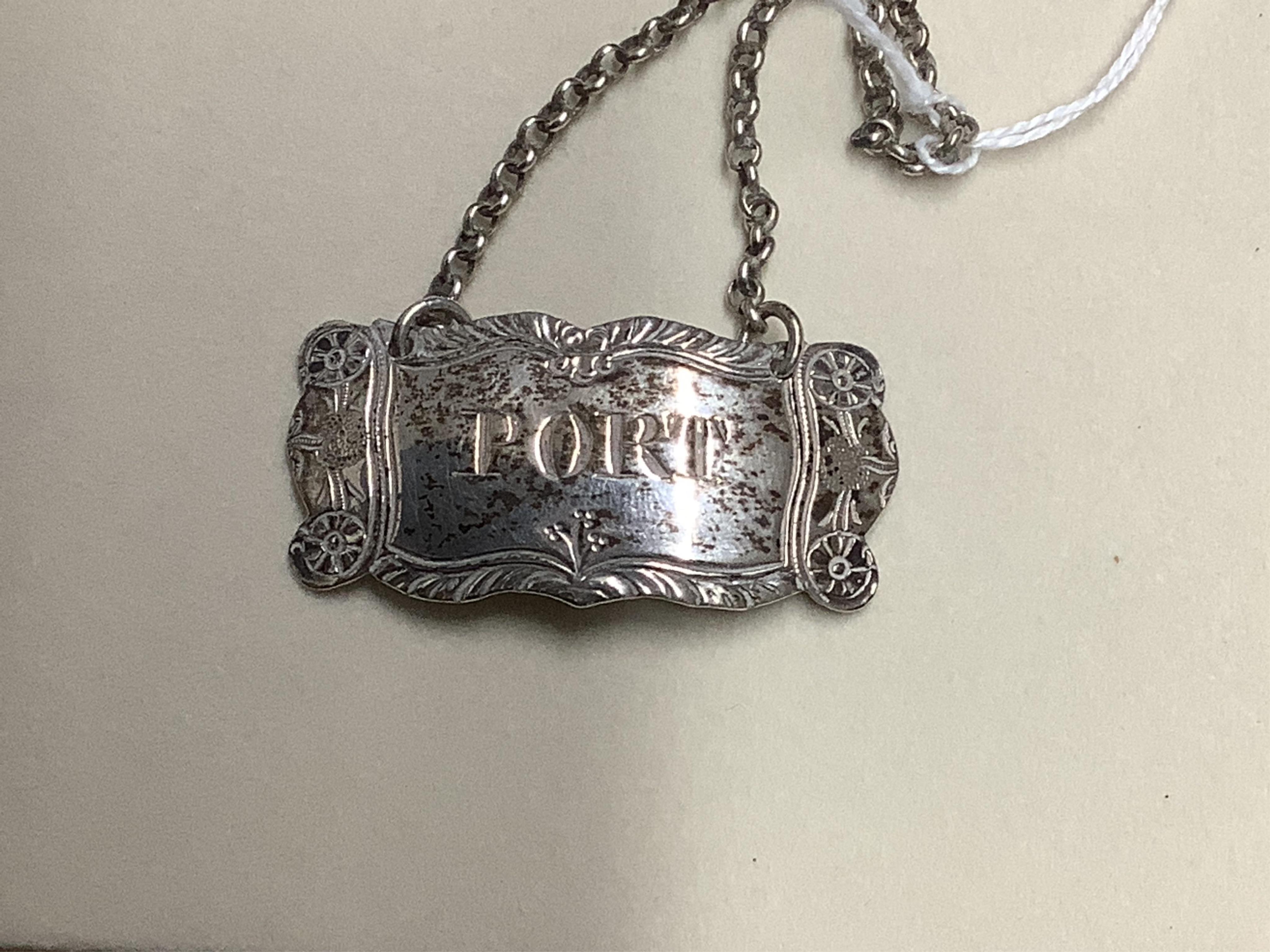 Four silver napkin rings including a pair, Sheffield, 1919, together with two George III silver wine labels, Claret, maker probably Abstinando King and Port, maker James Phipps I.